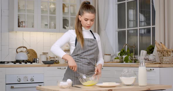 Young Lady Confectioner Mixing Dough in Glass Bowl Preparing Pastry at Home Kitchen Slow Motion