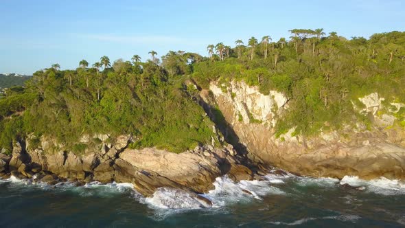 Aerial shot flying towards the Trilha da Sepultura at golden hour in Bombinhas, Brazil