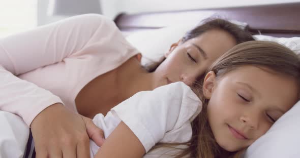 Mother and daughter sleeping on bed in bedroom at home 4k