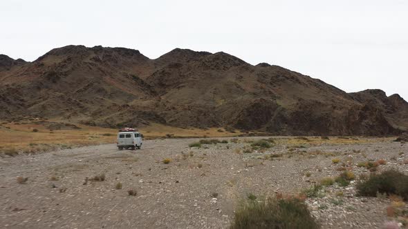 Offroad Vehicle Goes on a Dirt Road Among the Mountains