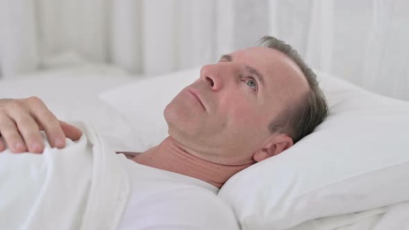 Worried Middle Aged Man Awake in Bed Thinking