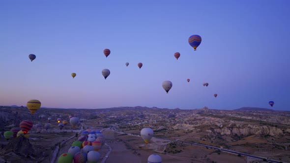 Aerial shot of many hot air balloon flying over idyllic Love Valley in natural park, Cappadocia