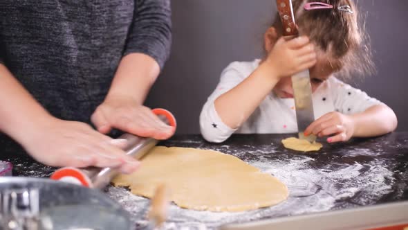 Mother and daughter baking sugar skull cookies for Dia de los Muertos holiday.