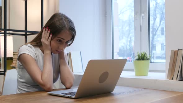 Young Girl Upset by Loss while Working on Laptop