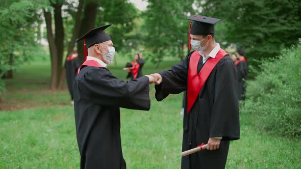 International University Graduation Teacher Congratulates the Man Student on Receiving Her Diploma