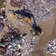Aerial top-down shot of claw loader handling recyclable materials into trash compactor - VideoHive Item for Sale