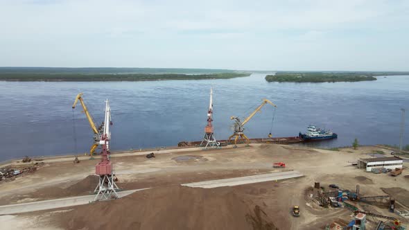 Large Harbor Cranes on the Shore at the Pier