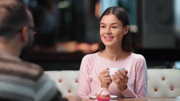 Happy Female Smiling Drinking Tea at Cafe Talking with Male on Date