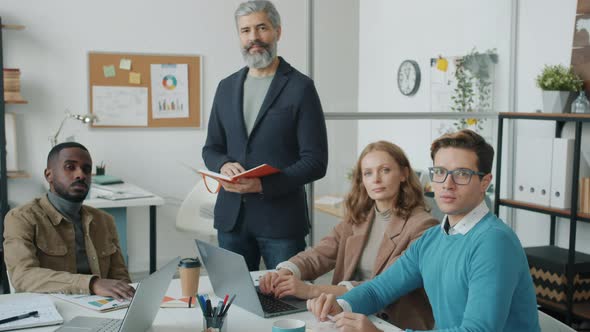 Diverse Group of Employees Male and Female Smiling and Looking at Camera Indoors in Modern Office