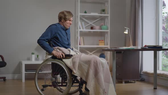 Wide Shot Motivated Young Disabled Man Trying Stand Up on Wheelchair Indoors at Home in Slow Motion