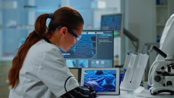 Scientist Using Digital Tablet Working in Modern Medical Research Laboratory