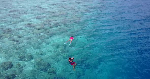 Daytime birds eye travel shot of a white paradise beach and aqua turquoise water background in color