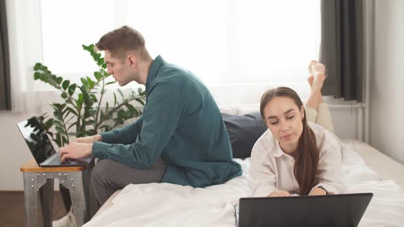 Young Caucasian Couple Use Laptop, Work at Home, Busy with Their Own Business.