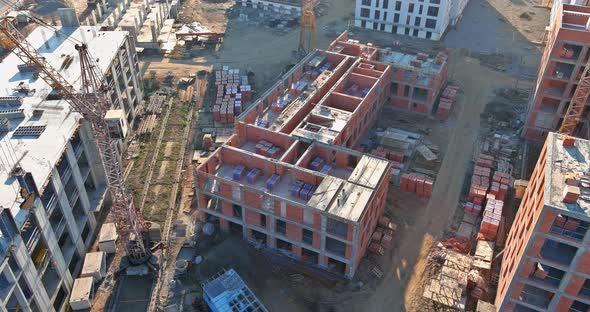 Aerial View with High Rise Building Under Construction at Tower Cranes