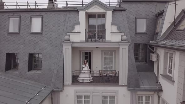 Bride in Wedding Dress on Balcony of Her House. Wedding Morning. Aerial View