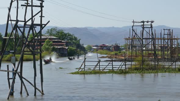 Long Boats Float Between Stilted Houses on Inle