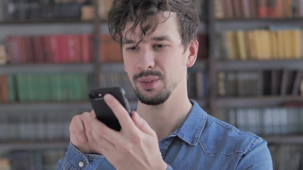 Portrait of Casual Young Man Busy Using Smartphone