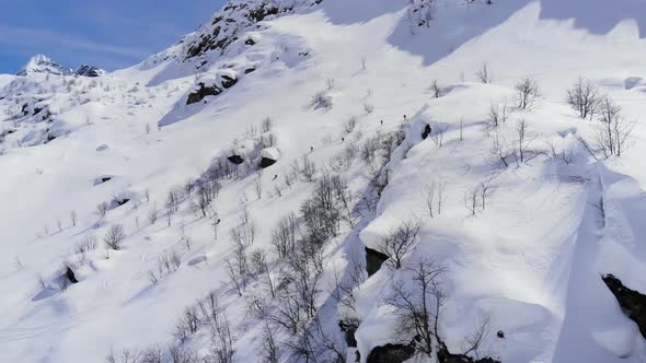 Group of people skiing down the mountain valley. Epic free ride scene.