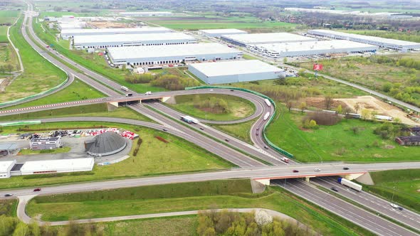 Aerial Shot of Industrial Warehouse Storage Building Loading Area where Many Trucks Are Loading Unlo