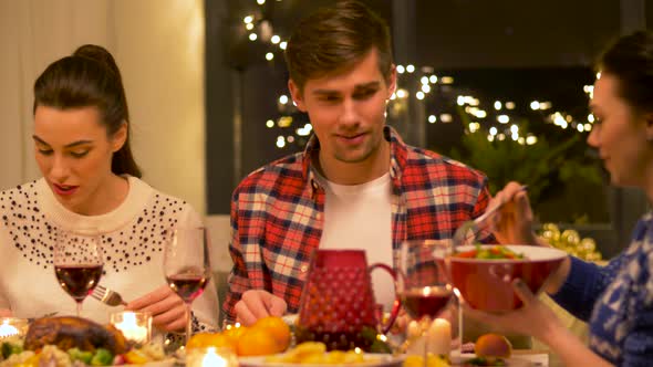 Happy Friends Having Christmas Dinner at Home