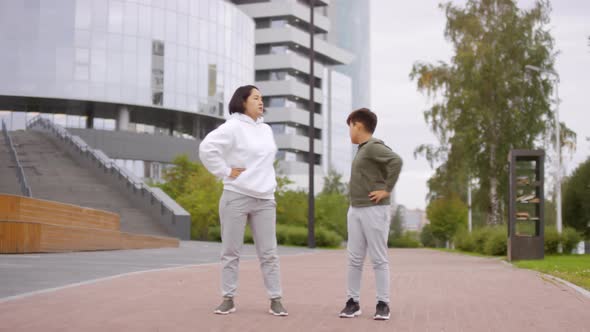 Asian Mother and Son Training Outdoors in City Center