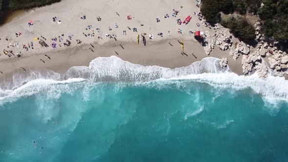 hustle and bustle at the breathtakingly beautiful bay of cala luna with violent waves, bird's eye vi