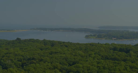 Aerial Pan of Dense Forest Trees and Bay Seen from a Distance in Long Island