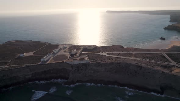 Sun kissed the oceanfront with shimmering sea from Fortaleza de Sagres fortress Algarve Portugal.