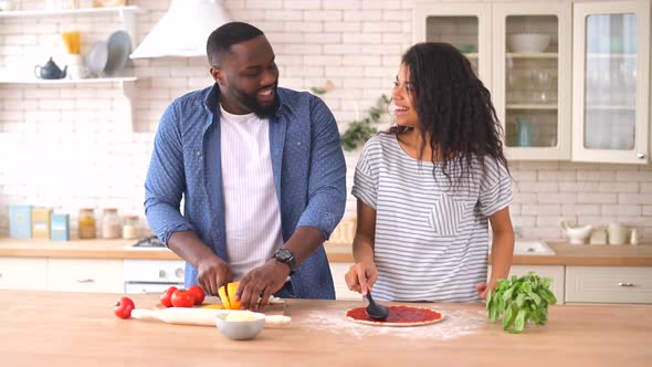 Happy Multiracial Couple Preparing Pizza Together at Home