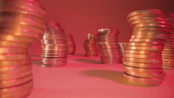 Curved Stacks of Shiny Golden Coins on Table at Red Light