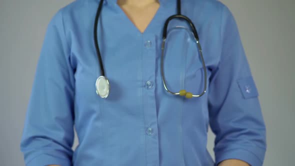 Female Physician in Blue Coat Warning About Serious Diseases, Holding Stop Sign