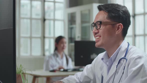 Asian Male Doctor Communicates With Patient By Video Link, Doctor Consults Patient