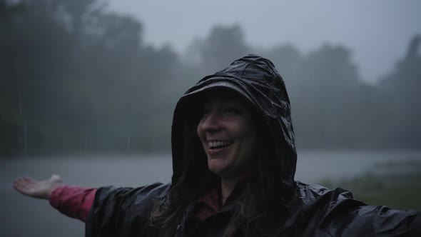 Young Girl in Raincoat Smiles and Laughs in the Rain