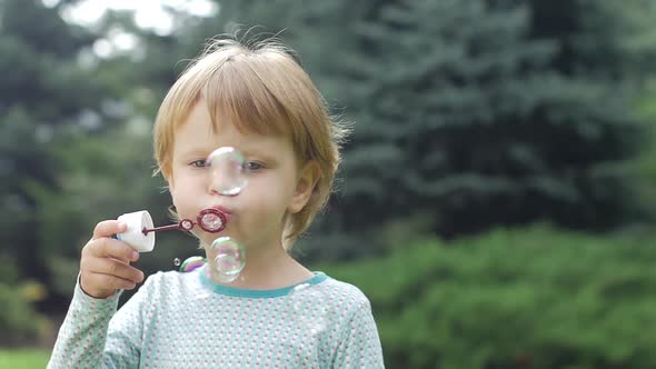 Little Girl with Soap Bubbles. Slow Motion. Close Up