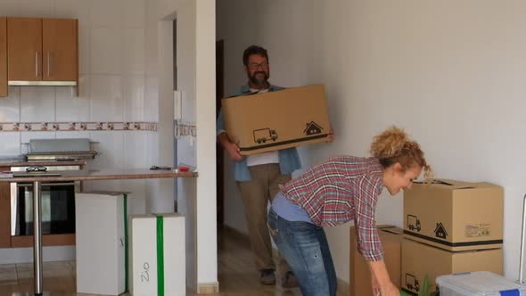 two happy people giving a hug after buy a new house or apartment relocating some boxes and packs