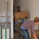 two happy people giving a hug after buy a new house or apartment relocating some boxes and packs - VideoHive Item for Sale