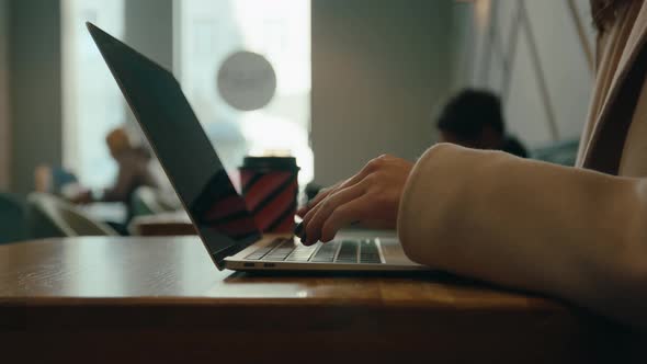 Young Woman Work on Laptop in Cinematic Cafe