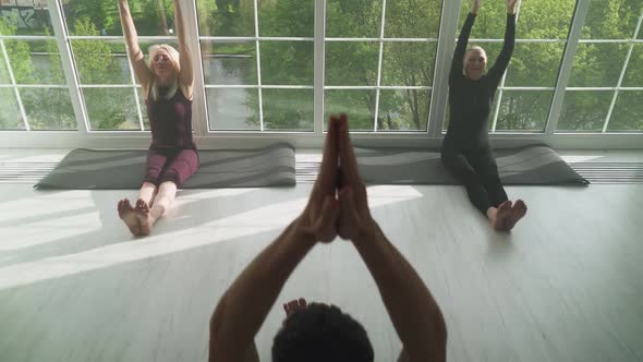 Wellness Joint Yoga Classes a Man Teaches Yoga to Two Adult Women People of Different Ages Doing