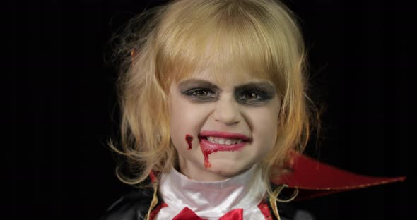 Dracula Child. Girl with Halloween Make-up. Vampire Kid with Blood on Her Face