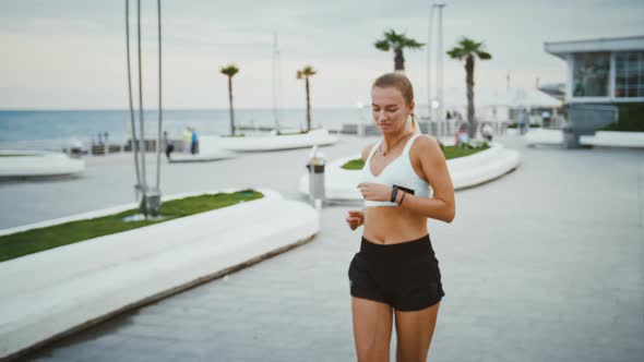 Active Woman with Prosthesis Looking at Smartwatch During Run Training Outdoors Close Up