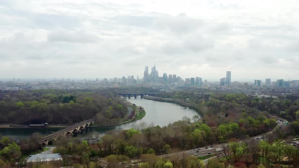 Aerial drone rising above to view Philadelphia city skyline over the Schuylkill river and highway tr
