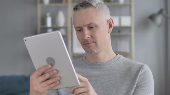 Gray Hair Man Using Tablet at Workplace