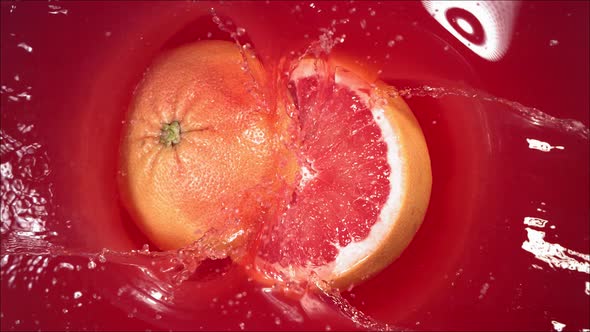 Grapefruit Falling on Juice with Splash and Divided in Half