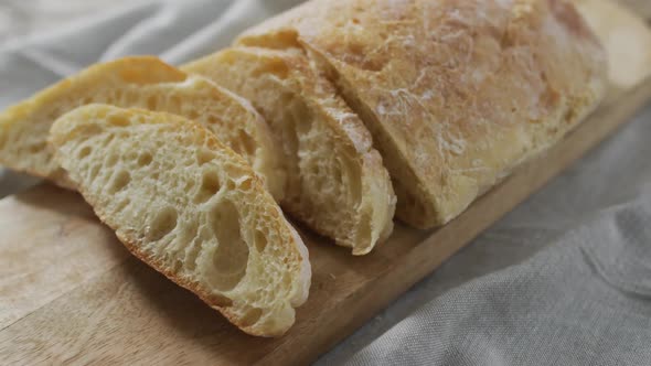 Video of bread on chopping wooden board on wooden worktop