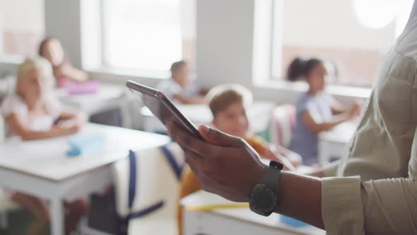 Video of hands of african american male teacher with tablet during lesson alt