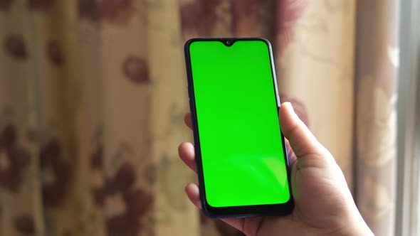 Top View of Women Hand Holding Smart Phone on Table