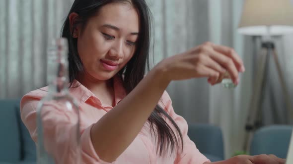 Close Up Of Drunk Asian Woman Drinking Vodka During Having Video Call On A Laptop At The Home