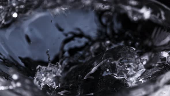 Super Slow Motion Macro Shot of Ice Cube Falling Into Glass With Vodka at 1000 Fps
