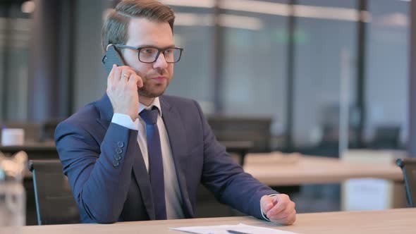 Businessman Talking on Phone in Office