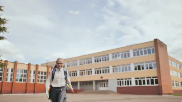 Happy Elevenyear Schoolgirl Runs with a Backpack After School